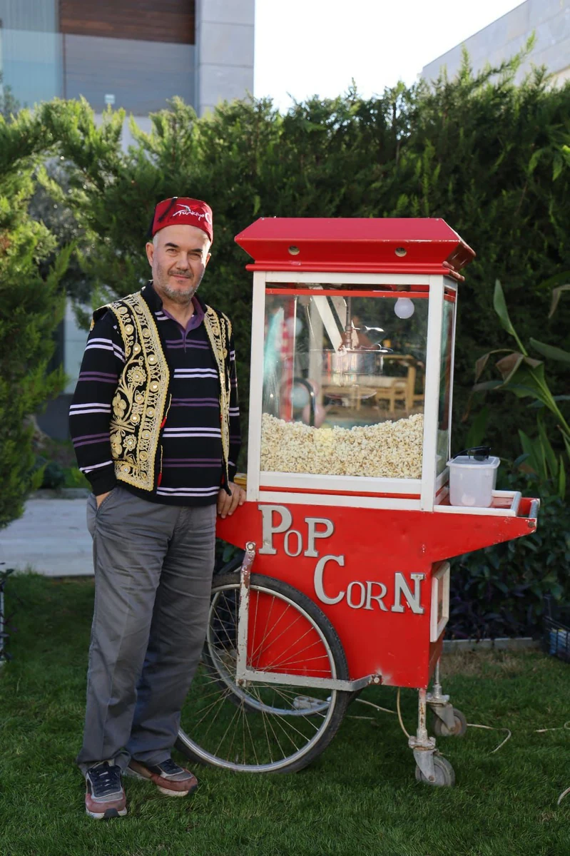 Görevli personel ve kırmızı patlamış mısır arabası