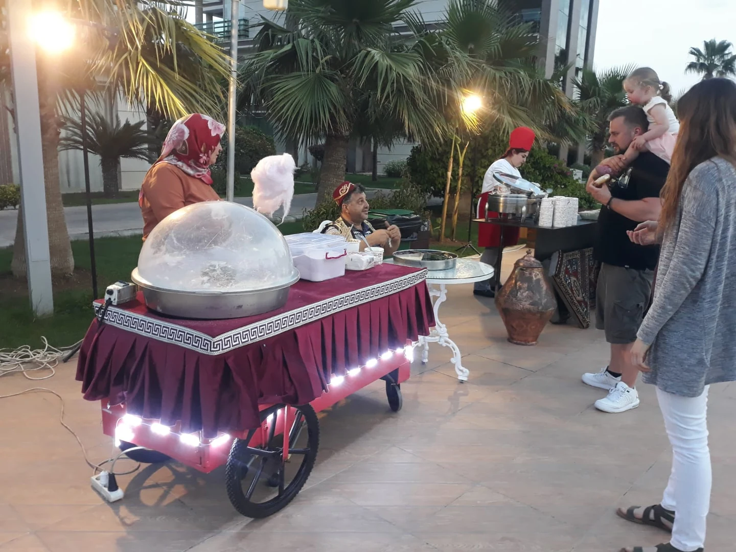 Otel bahçesinde pamuk şeker servis arabası ve etkinlik katılımcıları